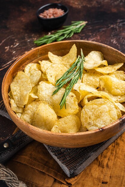 Patatine fritte fatte in casa con sale marino e rosmarino in un piatto di legno Sfondo scuro Vista dall'alto