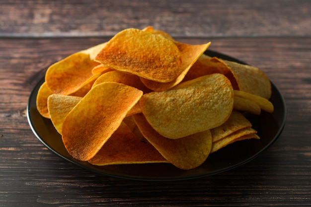 Patatine fritte su sfondo in legno. Spuntino croccante salato