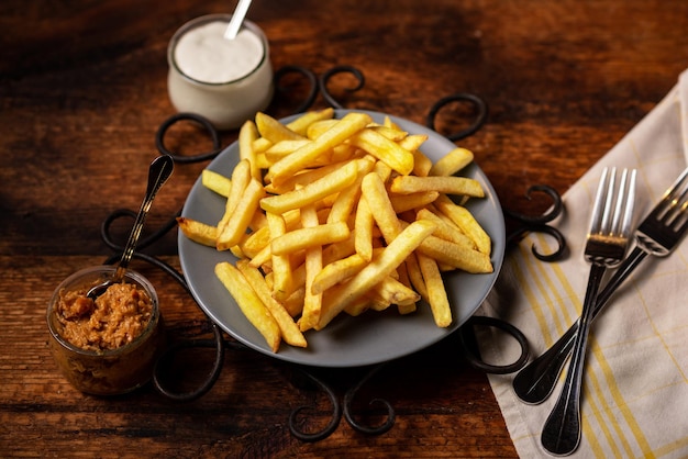 Patatine fritte su un piatto su uno sfondo di legno Spicchi di patate color oro