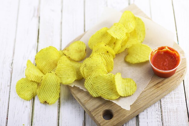 Patatine fritte su un vassoio di legno su una tavola bianca