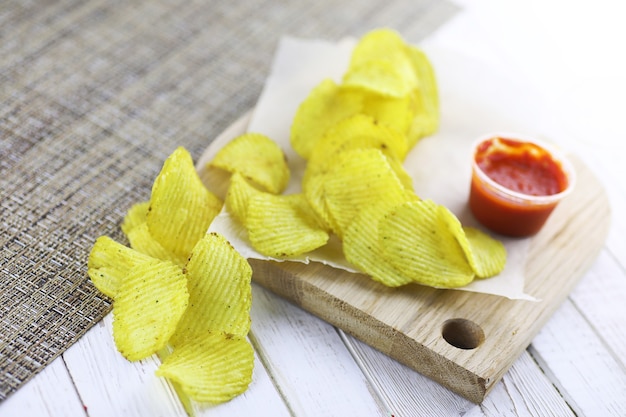 Patatine fritte su un vassoio di legno su una tavola bianca