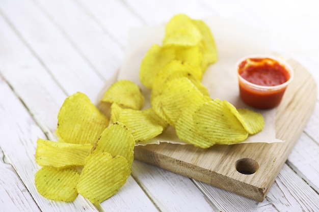 Patatine fritte su un vassoio di legno su una tavola bianca