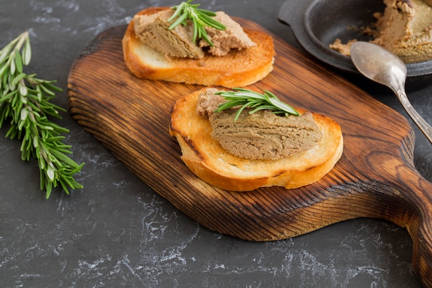 Patè di carne fatto in casa su pane croccante tostato. stile fotografico scuro.