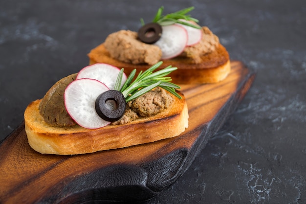 Patè di carne fatto in casa su pane croccante tostato. stile fotografico scuro.