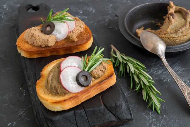 Patè di carne fatto in casa su pane croccante tostato. stile fotografico scuro.