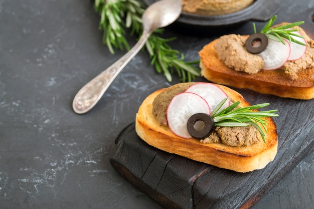 Patè di carne fatto in casa su pane croccante tostato. stile fotografico scuro.