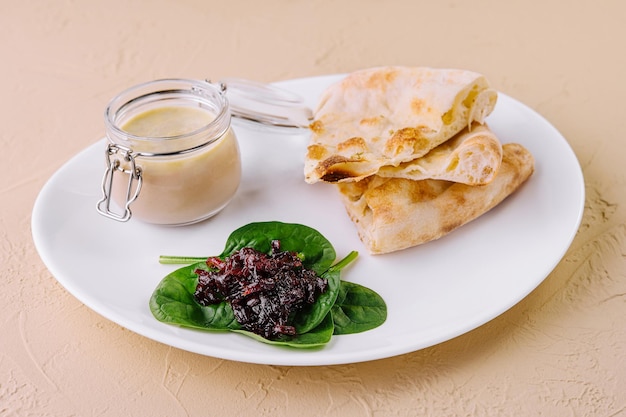 pate di pollo con marmellata di cipolla e pane pita servito in un piatto bianco