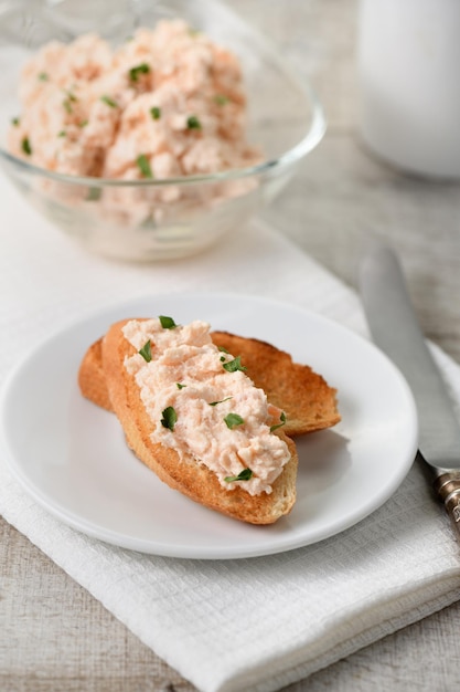 Patè di salmone con formaggio morbido e fette di pane tostato alle erbe Coltello vintage con tovagliolo in tessuto