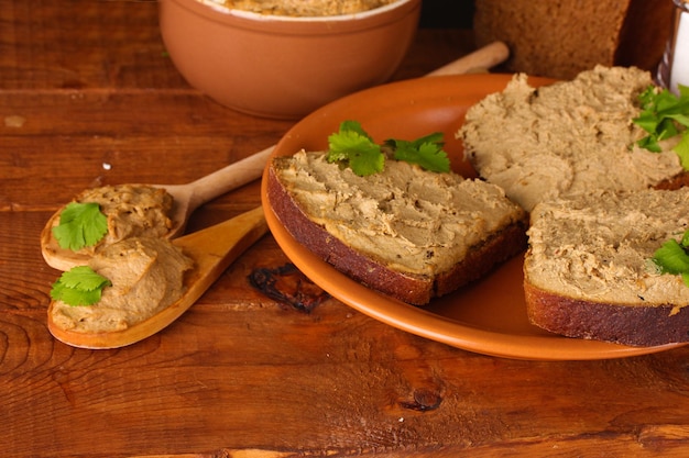 Patè fresco con pane su tavola di legno