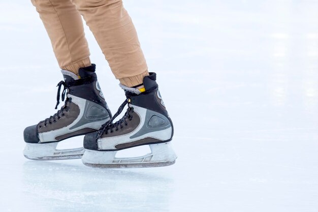 Pattinaggio su ghiaccio su una pista di pattinaggio gambe con pattini Sport invernali attivi e hobby per il tempo libero