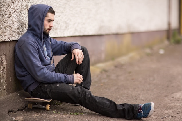 Pattinatore che fa una pausa fuori dallo skate park