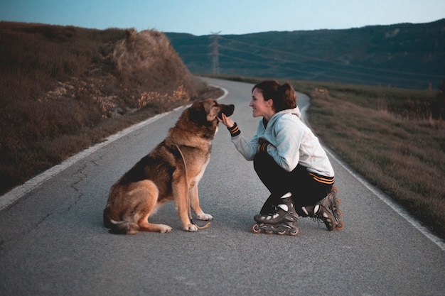 Pattini della ragazza con il suo cane