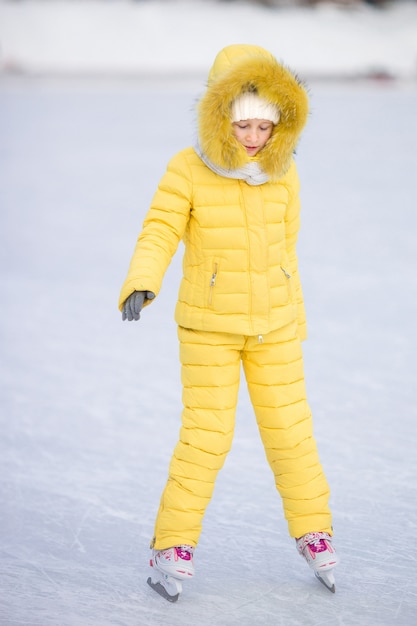Pattino andante della bambina adorabile nel giorno della neve di inverno all&#39;aperto