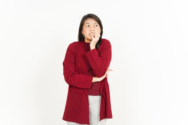 Paura, nervosa e mordere le unghie di una bella donna asiatica che indossa una maglietta rossa isolata su sfondo bianco