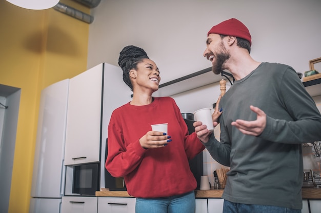 Pausa caffè. Colleghi che prendono un caffè nella cucina dell'ufficio e hanno una vivace conversazione