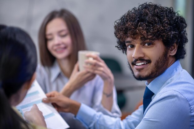 Pausa caffè. Giovani seduti in mensa a discutere di qualcosa