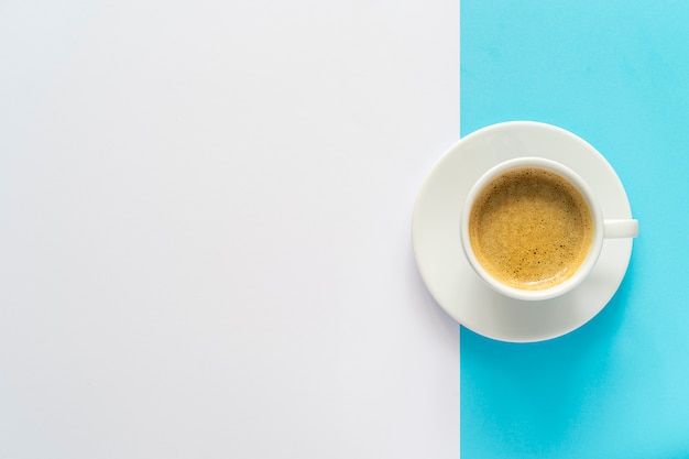 Pausa caffè. Modello minimo del fondo bianco e blu con una tazza di caffè. Copia spazio.