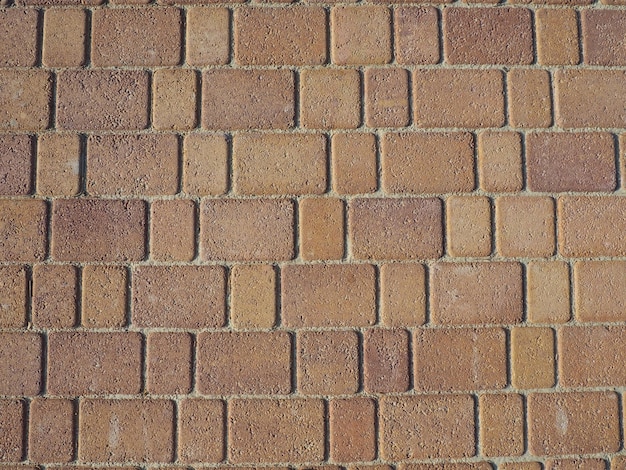 Pavimentazione colorata Piastrelle rettangolari e quadrate in una calda tonalità marrone sotto l'illuminazione obliqua della sera Pietre per lastricati in Kerch Stone sullo sfondo