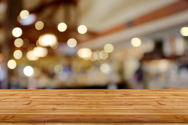 Pavimento di un tavolo di legno vuoto con uno sfondo di ristorante bokeh