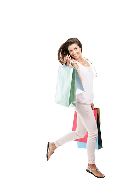 Payday is splurge day Ritratto in studio di una giovane donna felice che trasporta borse della spesa su uno sfondo bianco