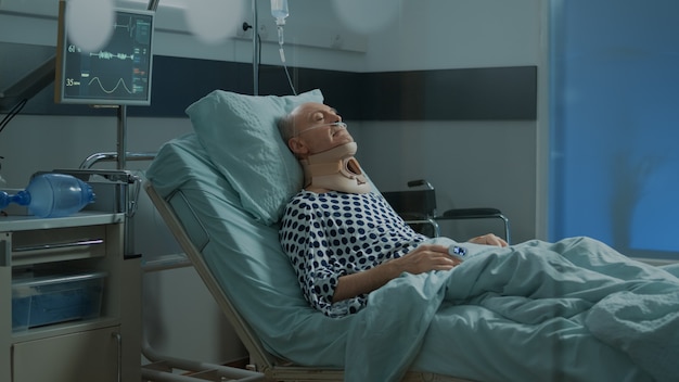 Paziente anziano con collare cervicale ricoverato in reparto ospedaliero