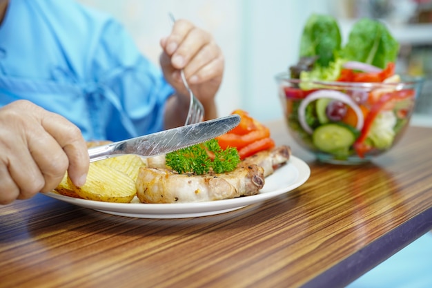 Paziente anziano della donna anziana anziana o anziana della donna che mangia prima colazione