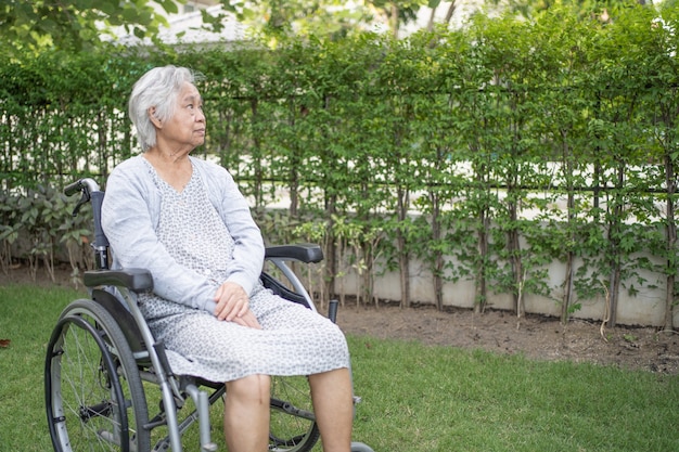 Paziente asiatico anziano o anziana della signora anziana su sedia a rotelle nel parco, forte concetto medico sano.