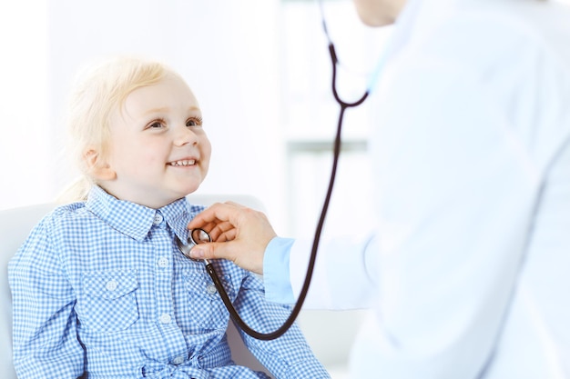 Paziente bambino sorridente felice alla normale ispezione medica. Medico e paziente in clinica. Medicina, concetti sanitari.