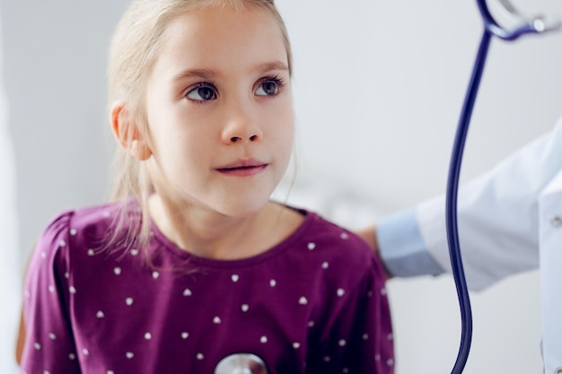 Paziente della ragazza del bambino alla consueta ispezione medica. Medico e bambino paziente a casa. Medicina, concetti sanitari.