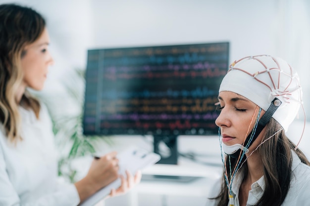 Paziente di sesso femminile in un laboratorio di neurologia che esegue la scansione EEG