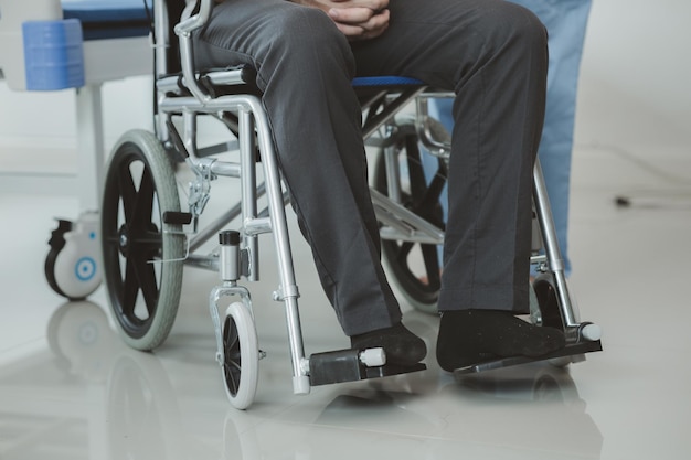 Paziente di sesso maschile seduto su sedia a rotelle sottoposto a visita medica con un medico specialista che cura le lesioni Ottenere cure mediche da un medico specialista può ottenere il trattamento giusto e adeguato