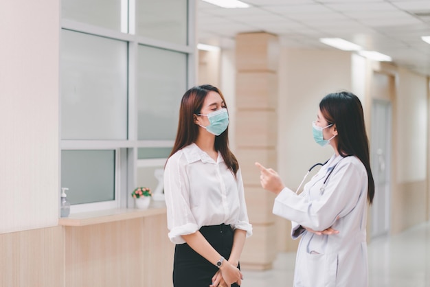 Paziente donna asiatica che parla con il medico in ospedale, concetto di assicurazione sanitaria