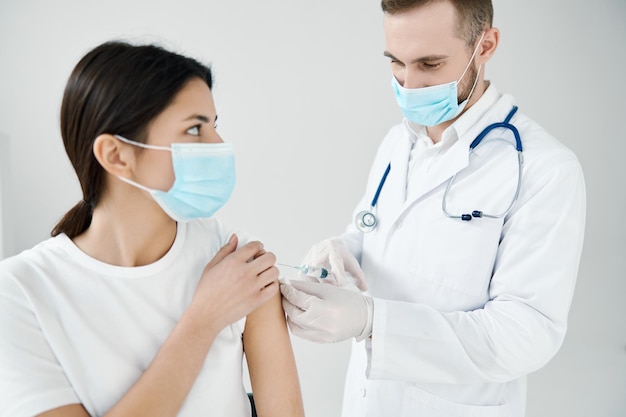 Paziente donna con maschera medica e medico con siringa per la vaccinazione Foto di alta qualità