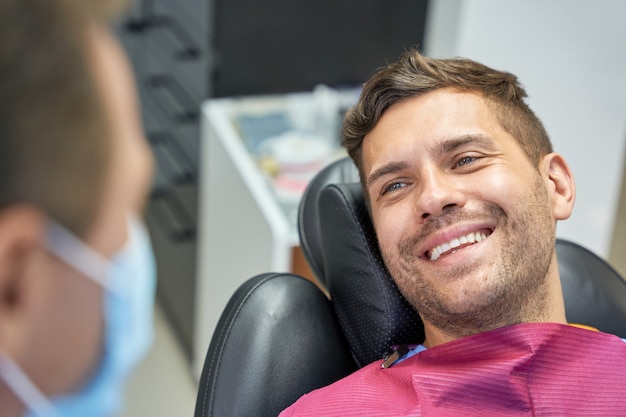 Paziente felice che ha un appuntamento dal dentista in una clinica moderna