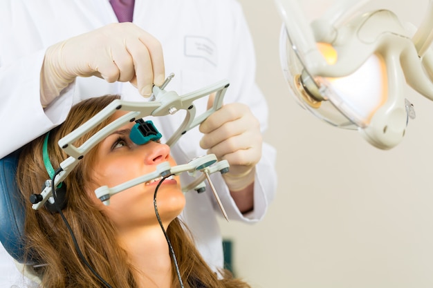 Paziente femminile con trattamento dentistico dentista, indossando guanti