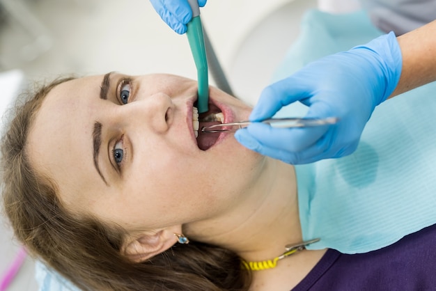 Paziente in odontoiatria con strumenti stomatologici, primo piano