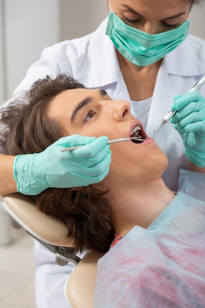 Paziente maschio e dentista femmina in una clinica odontoiatrica