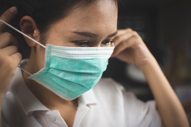 Paziente ragazza asiatica che indossa una maschera medica per prevenire le infezioni e prevenire la diffusione del Coronavirus, prevenzione di Covid-19.