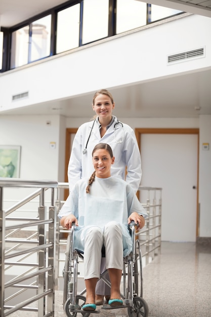Paziente seduto su una sedia a rotelle accanto a un medico