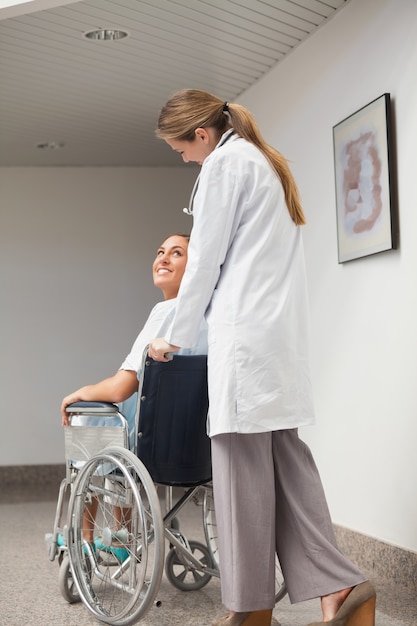 Paziente seduto su una sedia a rotelle guardando un medico