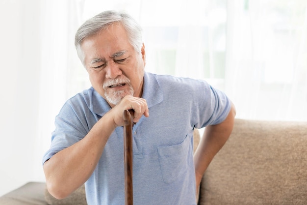 Pazienti anziani sul lettino Uomo anziano asiatico che soffre di mal di schiena concetto medico e sanitario