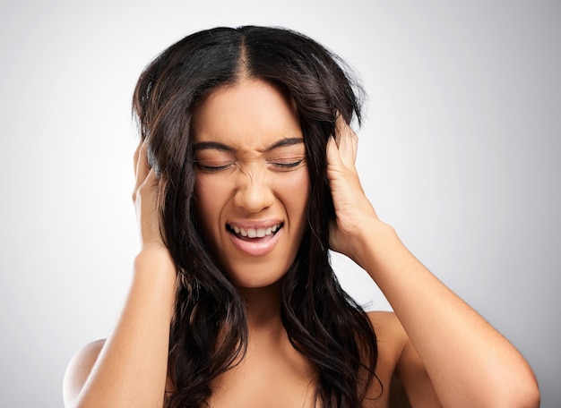 È pazza per i suoi capelli Foto ritagliata di una giovane donna attraente in posa in studio su uno sfondo grigio