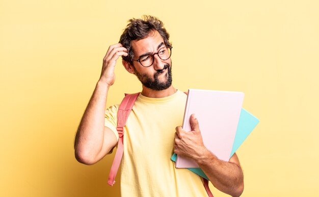 Pazzo espressivo che si sente perplesso e confuso, grattandosi la testa. concetto di studente adulto