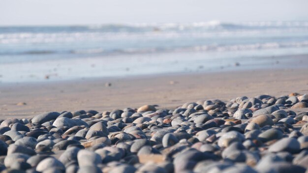 Pebble rocce spiaggia sabbiosa oceano mare acqua onde rotonde pietre lisce o masso