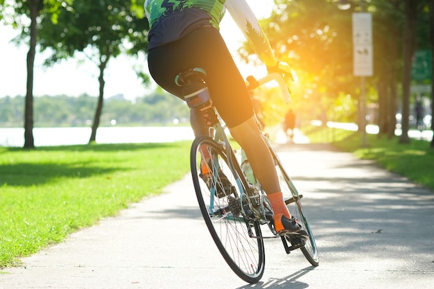 Pedala in bici lungo la strada nel parco cittadino. Sport e concetto di vita attiva nel periodo estivo