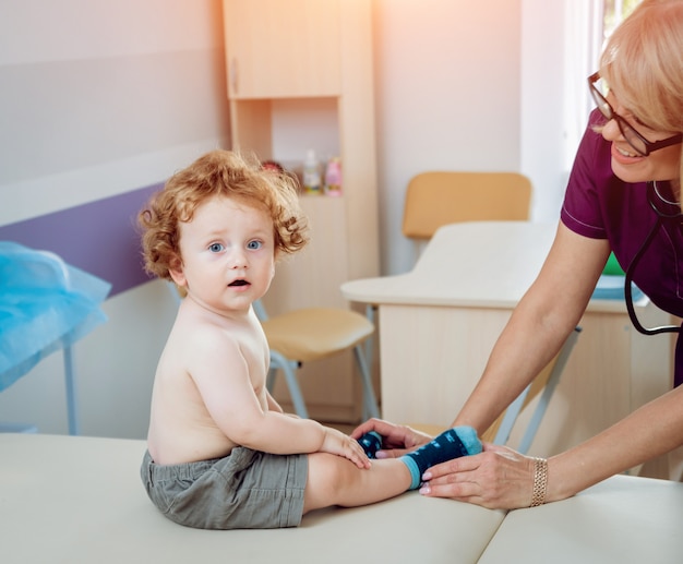 Pediatra amichevole di medico con il bambino paziente alla clinica