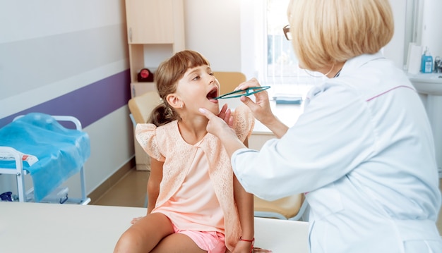 Pediatra amichevole di medico con il bambino paziente alla clinica