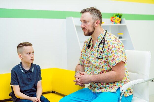 Pediatra attento che consulta un bambino. Visita medica.