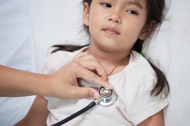 Pediatra che esamina il cuore della bambina asiatica