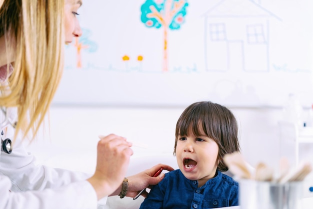 Pediatra che esamina la gola del ragazzino